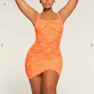 SKIMS STRETCH LACE SLIP DRESS IN NEON ORANGE